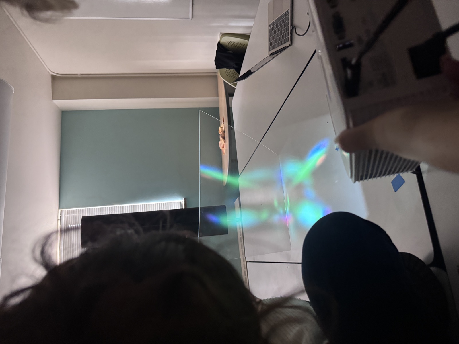 Early prototype testing the angled acrylic screen and projector, aurora-colored light visible